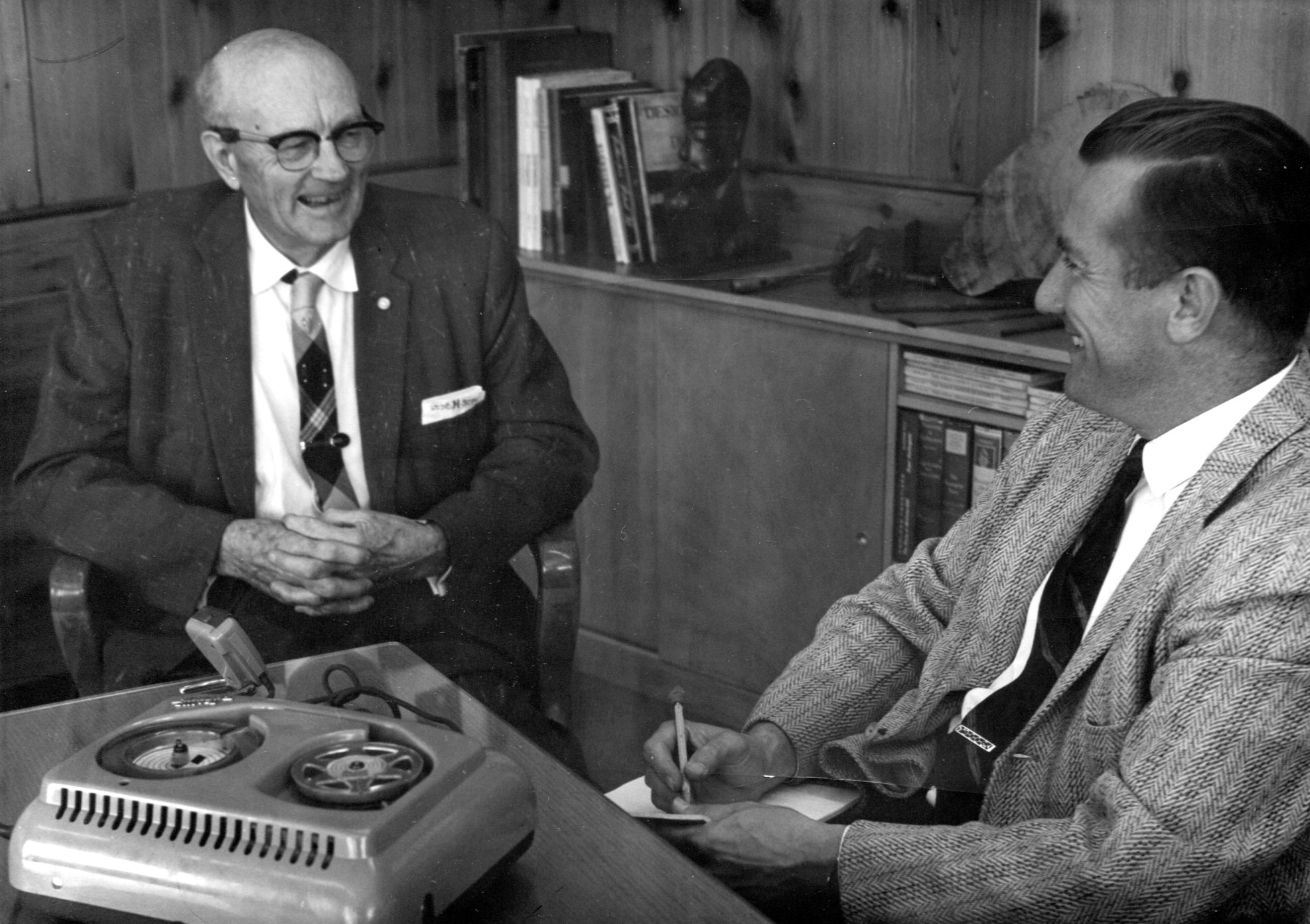 black and white photo of two men sitting and talking
