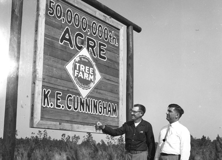 Kimbrell Cunningham, owner of the 50 millionth tree farm acre, and AFPI District Manager Harry Crown, view the sign on Cunningham's property.