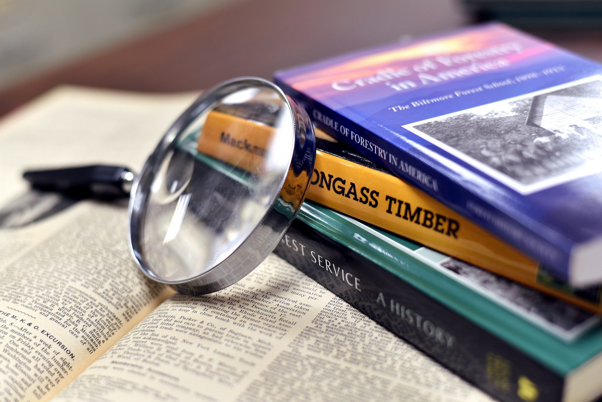 books with magnifying glass