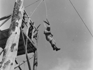 Smokejumper leaving 30-foot platform used for training jumps.