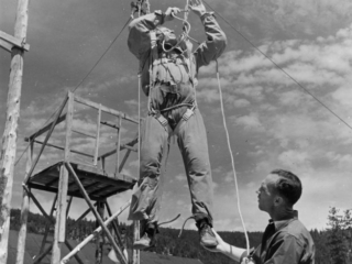 Frank Derry, parachute instructor-rigger, instructing prospective smokejumper.