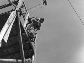 Smokejumper leaving 30-foot platform used for training jumps.