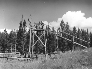 Smokejumper trainee in mid-air during jump from tower.