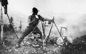 Harry T. Gisborne operating a double tripod heliograph, Tip Top Lookout, Wenatchee National Forest, Washington, 1915.