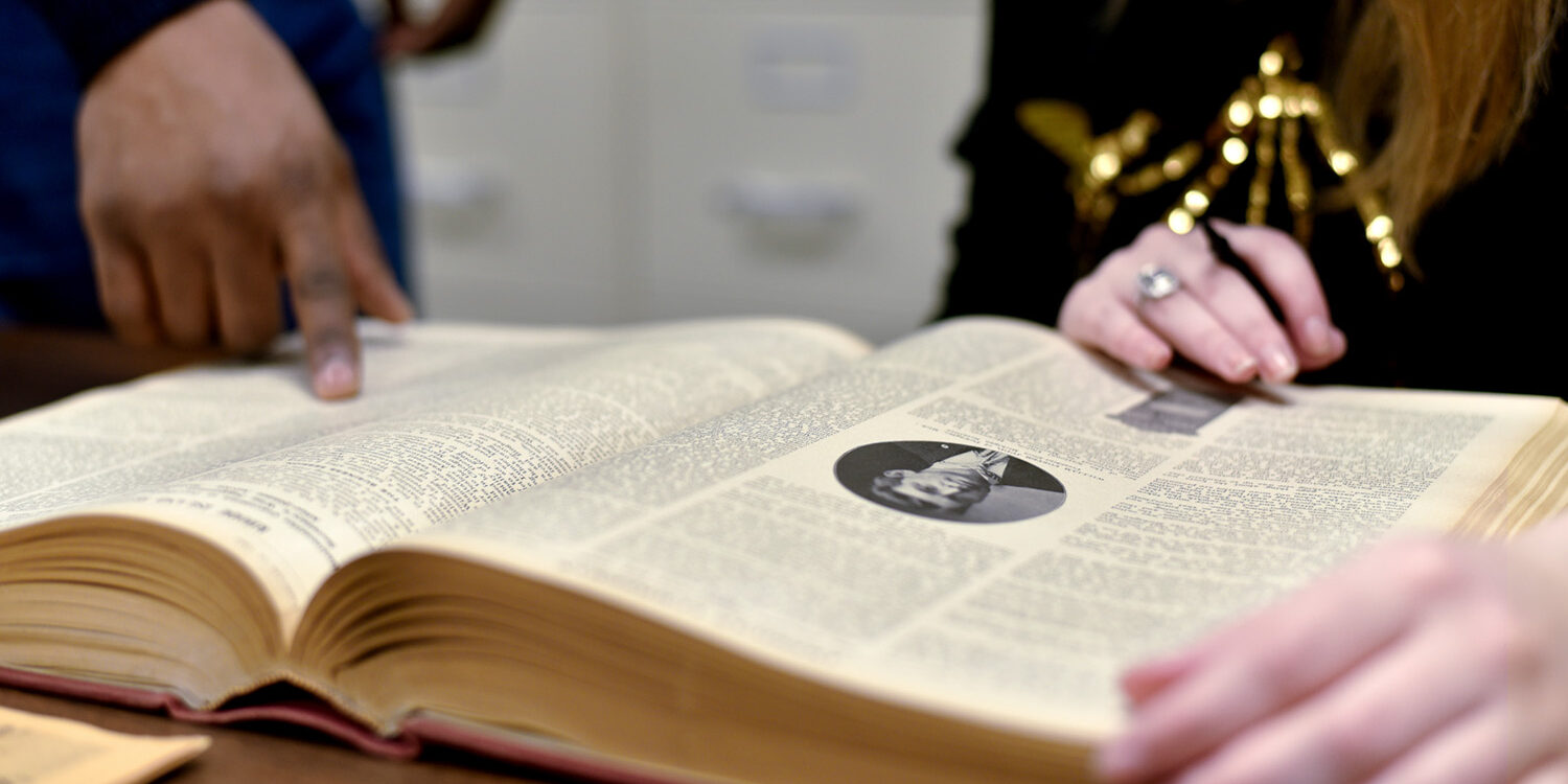 people looking through open research book